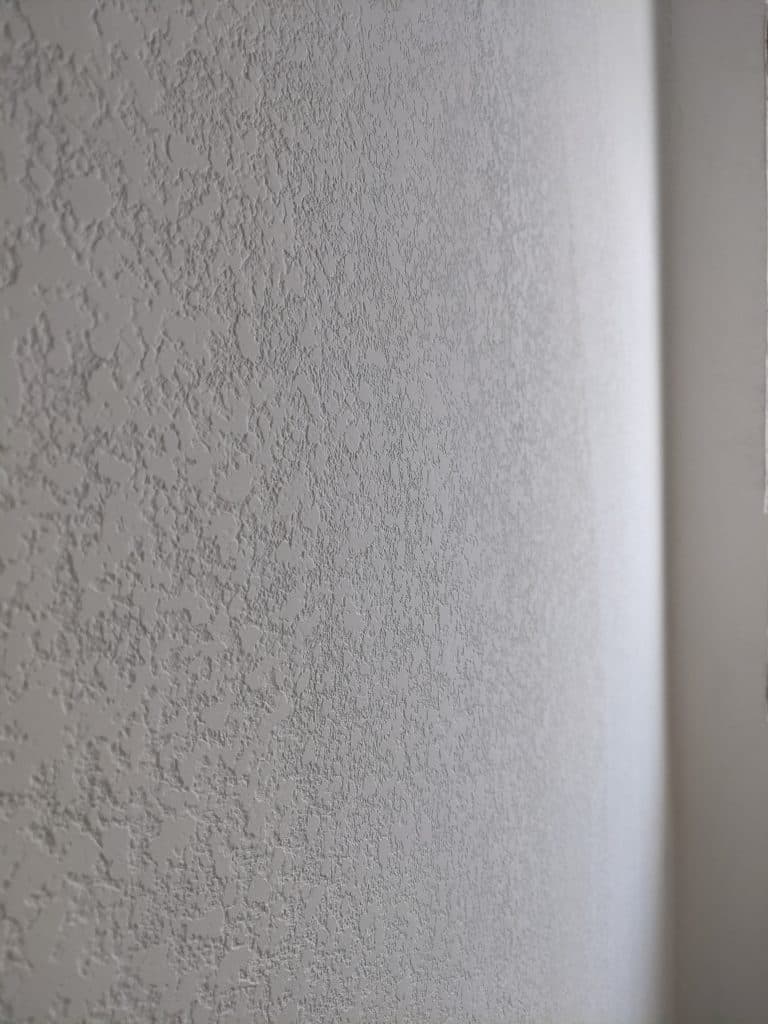 Close-up of a drywall wall with a uniform textured finish